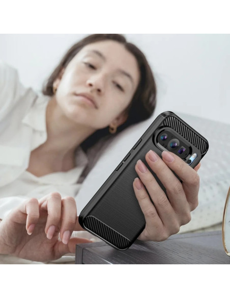 Google Pixel 9 / 9 Pro skal i svart, hålls i handen av en person som ligger på sängen