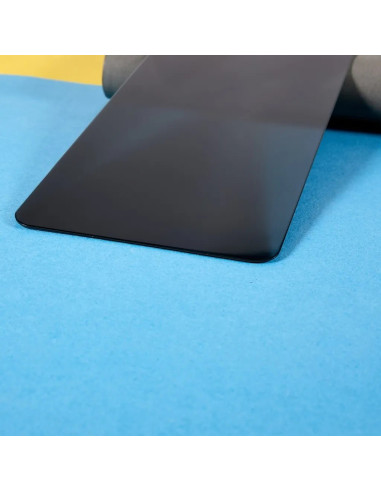 Privacy härdat glas för Google Pixel 9/9 Pro, liggande på en blå yta med fokus på de rundade kanterna