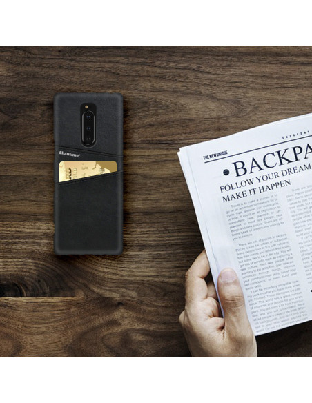 Svart Sony Xperia 1 skal med korthållare, placerat på ett bord med en tidning och en hand i bild