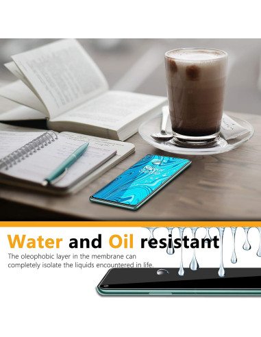 OnePlus 9 med härdat glas liggande på ett bord, omgiven av en bok och en kopp kaffe