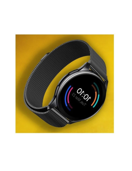 OnePlus Watch med svart Milanesisk loop armband, visande klockans skärm mot gul bakgrund