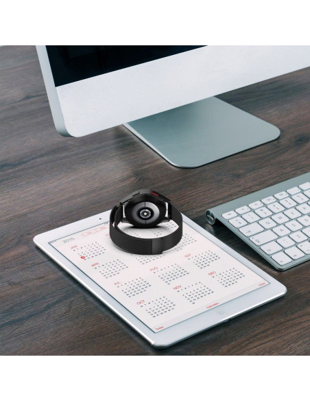 Samsung Galaxy Watch 4 med svart milanesisk loop armband, placerad på en surfplatta med kalender