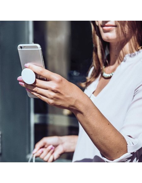 Självhäftande hållare i vit färg, använd av en person som håller en smartphone