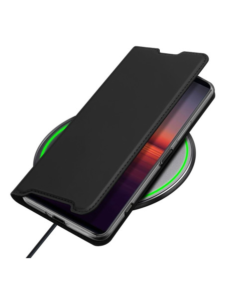 Svart Xperia 1 IV Flipfodral Skin Pro med stängt lock, placerat på en trådlös laddare