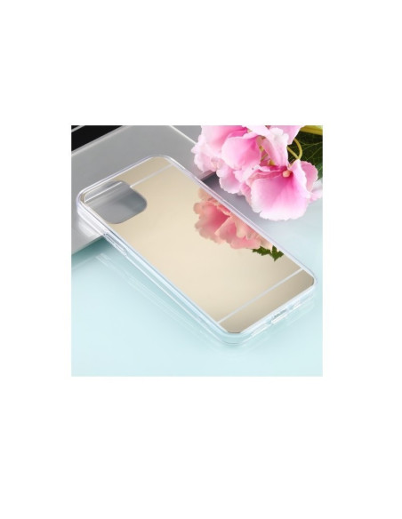 Spegelskal för iPhone 14 Plus med reflekterande yta, placerat på en ljus yta med blommor i bakgrunden