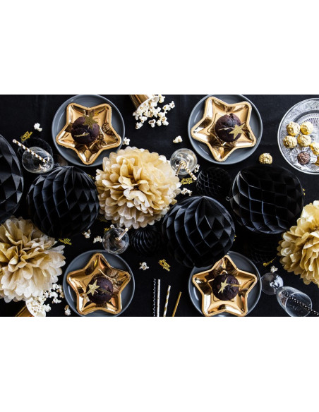 Guld konfetti med texten Happy New Year dekorerar ett festligt bord med svarta och guldiga detaljer