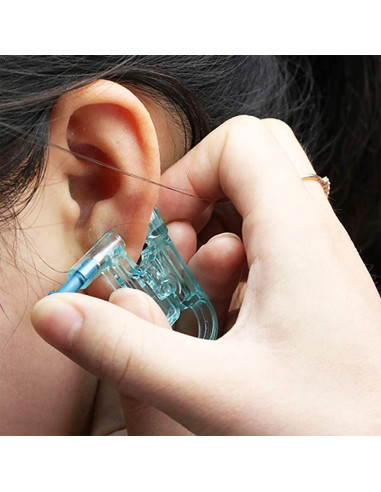 Närbild av öronpiercingverktyg i användning nära örat med fokus på grepp
