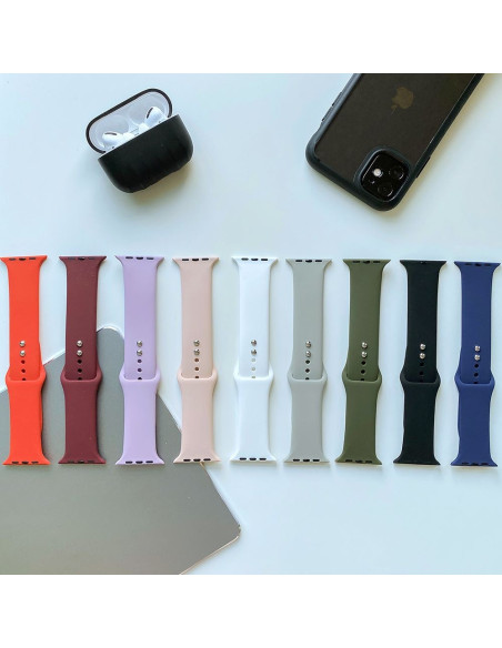 Flera silikonarmband för Apple Watch i olika färger, inklusive orange, på en yta