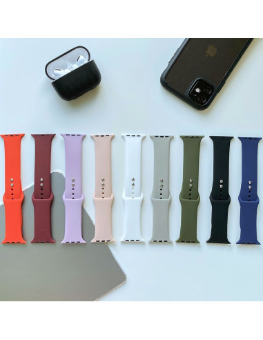 Rosa silikonarmband bland flera färgade armband för Apple Watch, sett ovanifrån